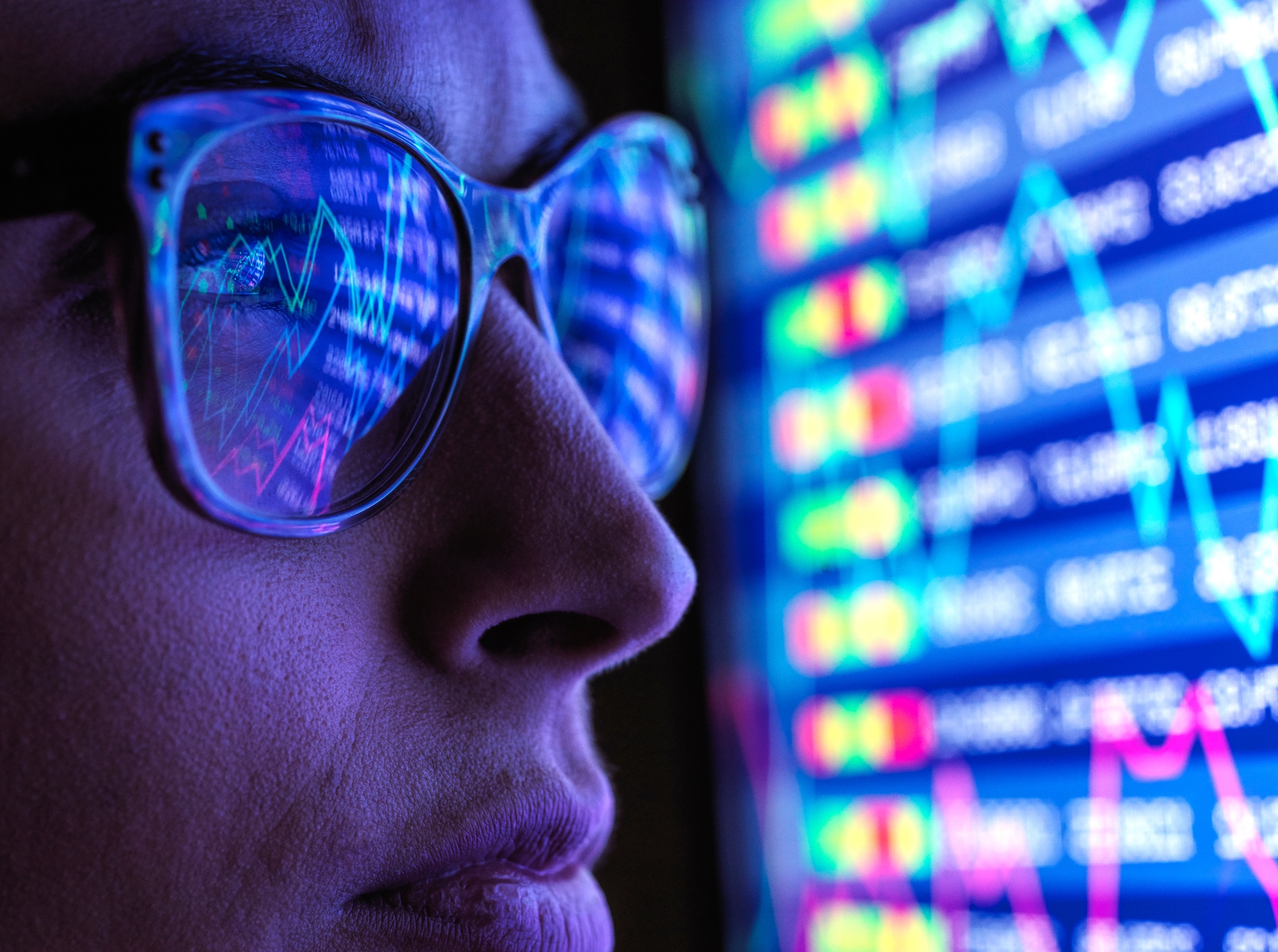 Person viewing financial market data and stock price charts on a screen