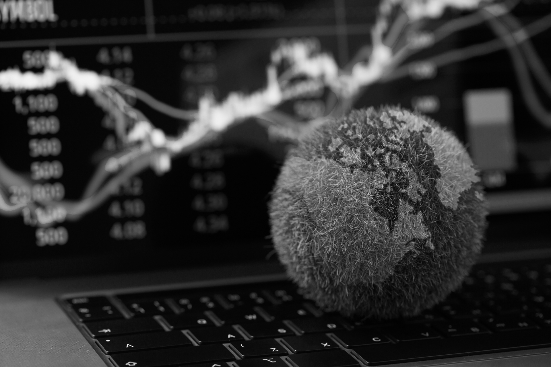 Globe covered in green vegetation in front of a financial market chart