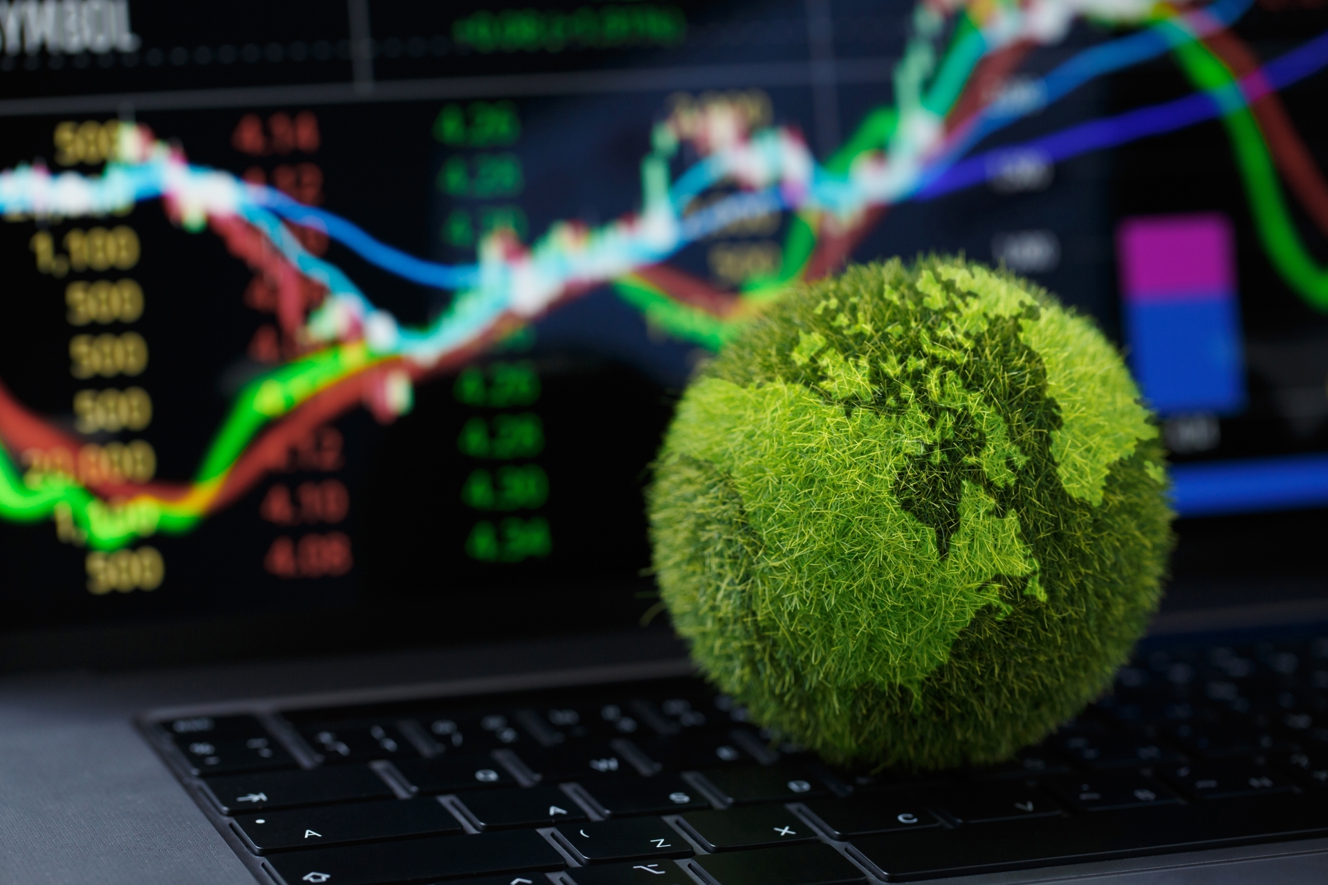 Globe covered in green vegetation in front of a financial market chart