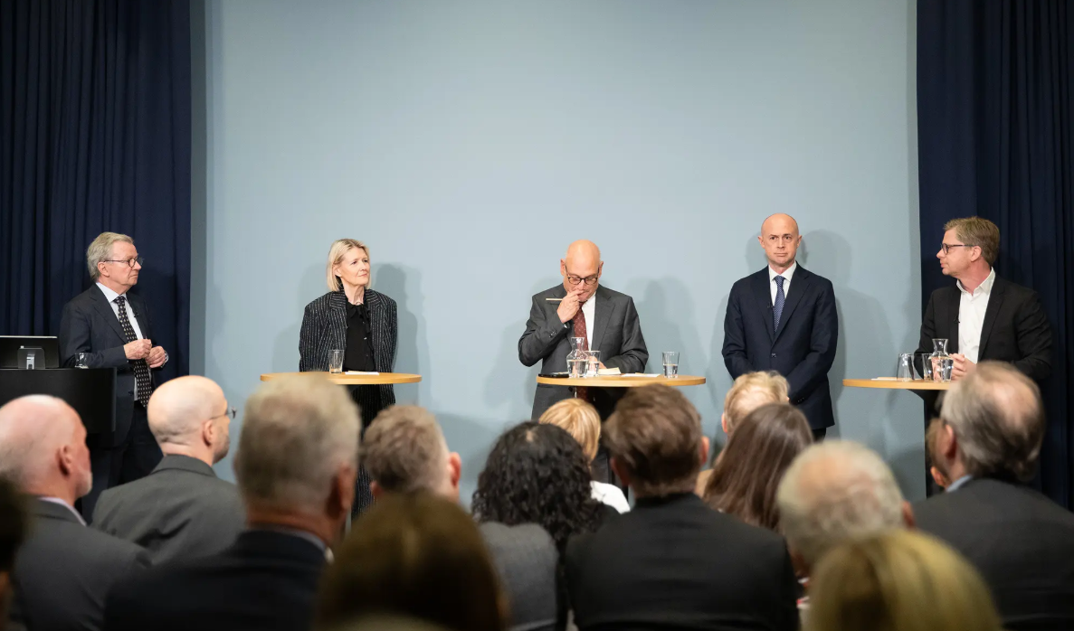 Five panelists participating in a discussion on stage